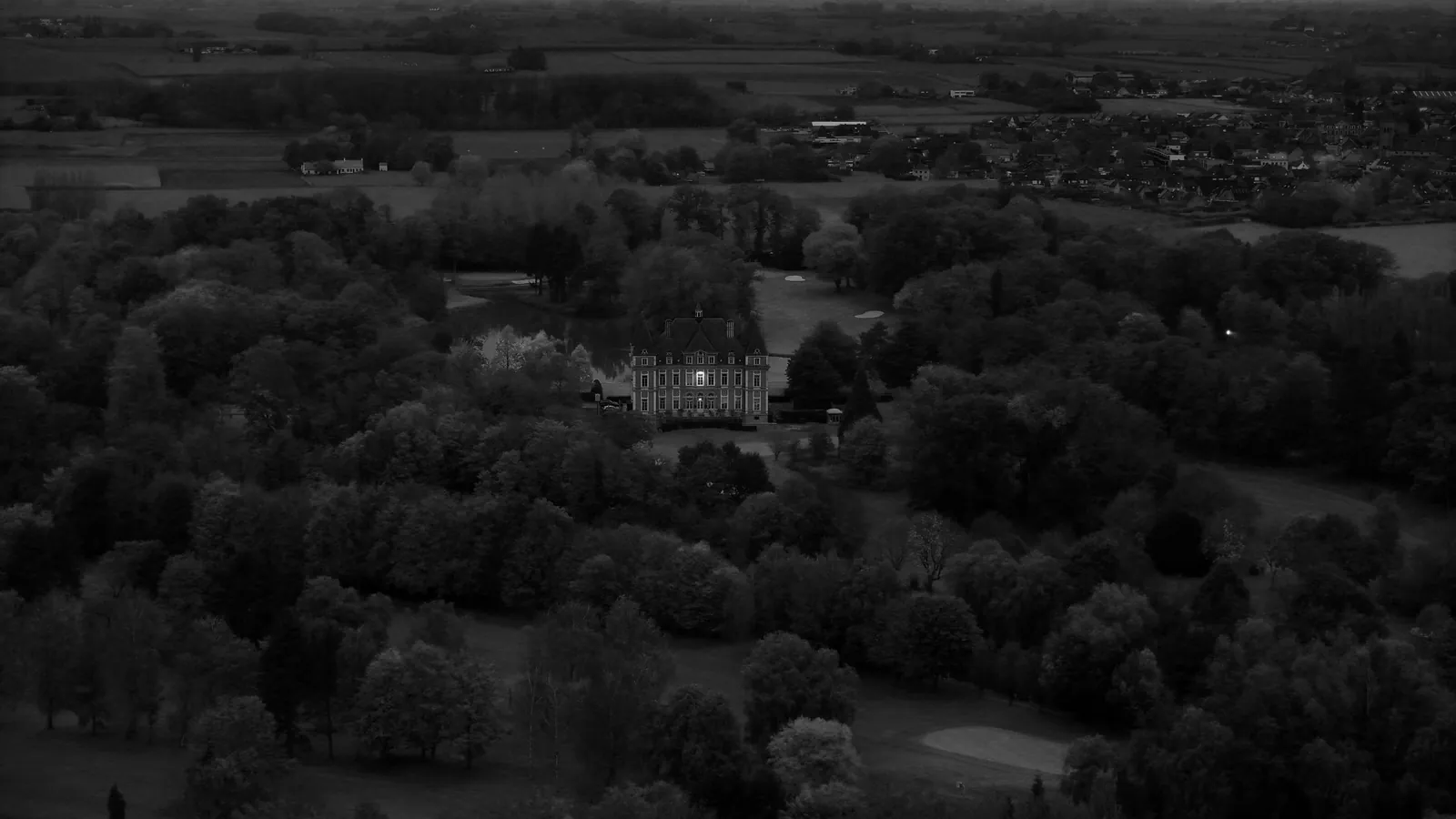 The castle of Golf Oudenaarde between the trees, in black and white