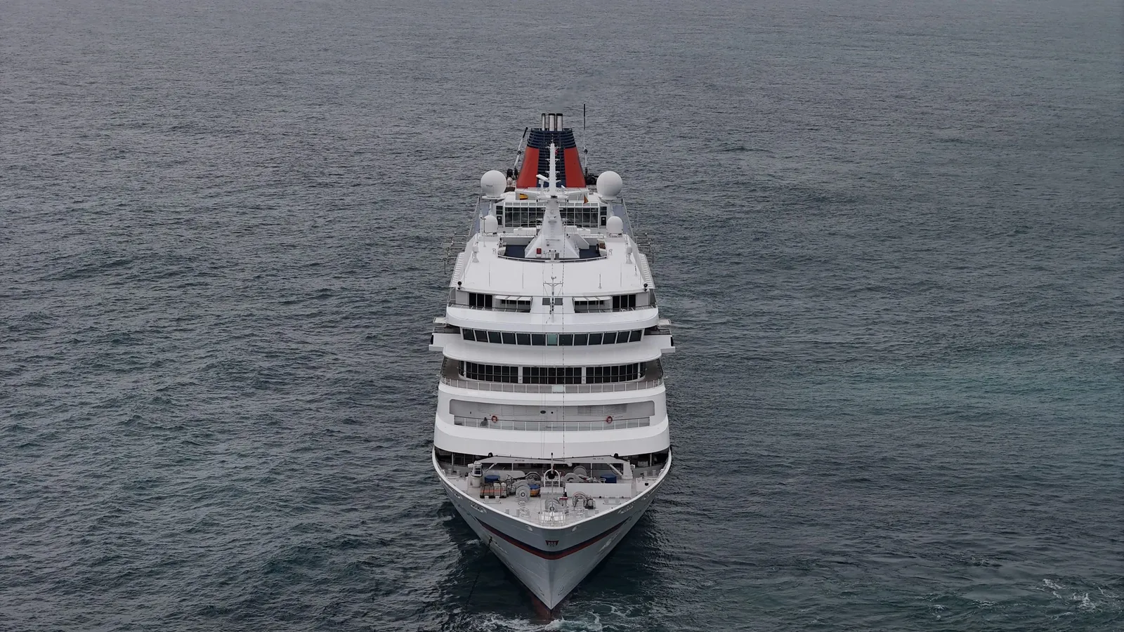 A cruise ship at sea, filmed head-on from a drone
